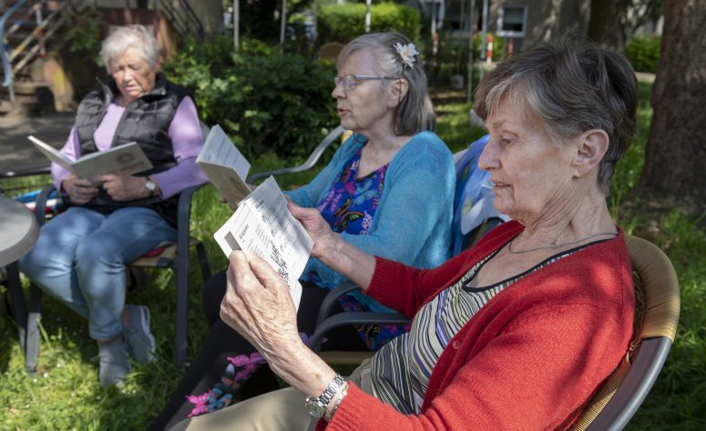 Damen lesen zusammen im Garten