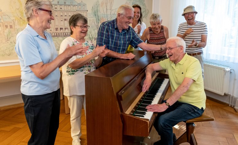ein Herr der Senioreninitiative Höchst spielt für die anderen Mitglieder Klavier