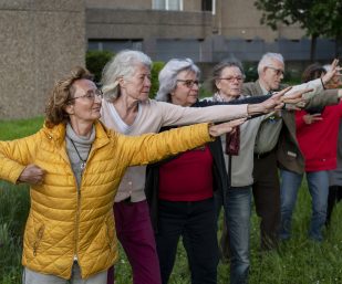 Ältere Menschen praktizieren Yogaübungen im Freien