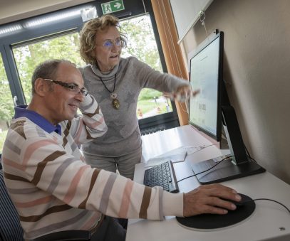 Herr zeigt Dame wie man mit einem Computer umgeht
