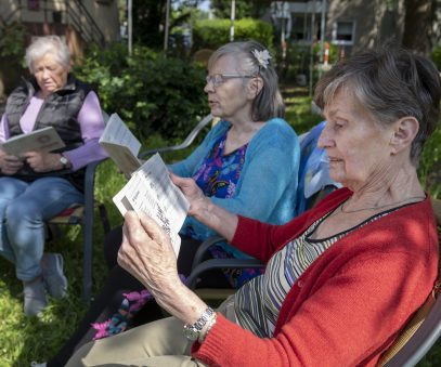 Damen lesen zusammen im Garten