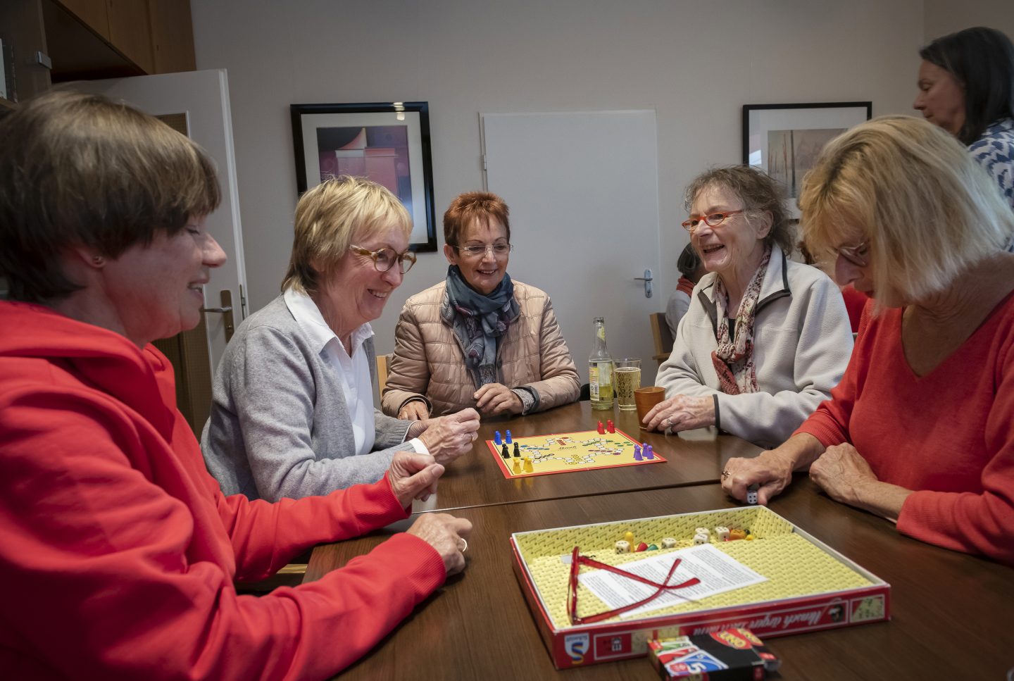 Damen machen zu fünft einen Spieleabend mit Brettspielen